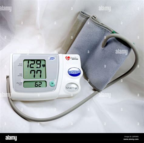 Blood pressure monitor and cuff showing blood pressure reading and pulse rate Stock Photo - Alamy