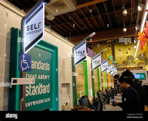 Row of automated self-checkout bays at a Whole Foods grocery store in ...