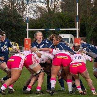 Women playing rugby in an outdoor match