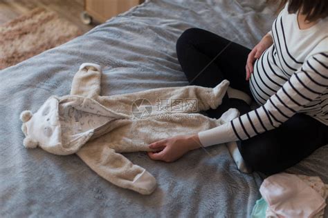 孕妇做梦和抱着婴儿的衣服高清图片下载-正版图片507410599-摄图网