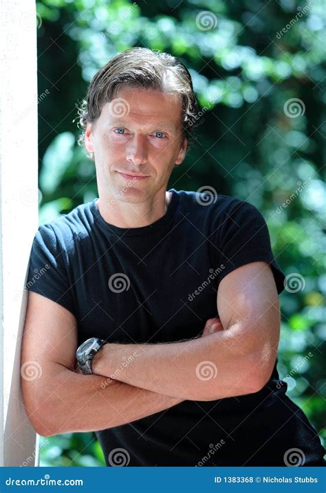 Handsome Middle Aged Man Leaning Against Wall in the Sun Stock Photo ...