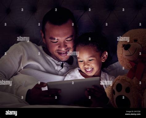 Man, child and digital tablet streaming movies, cartoon or game in bed ...