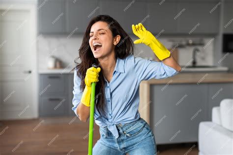Premium Photo | Energetic woman singing with mop in stylish kitchen