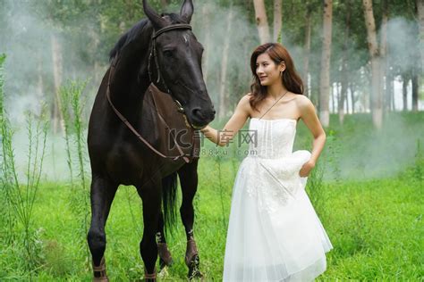 树林里漂亮的青年女人牵着马高清摄影大图-千库网