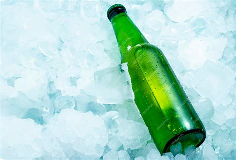 Premium Photo | Bottle of green beer in very cold ice cubes horizontal