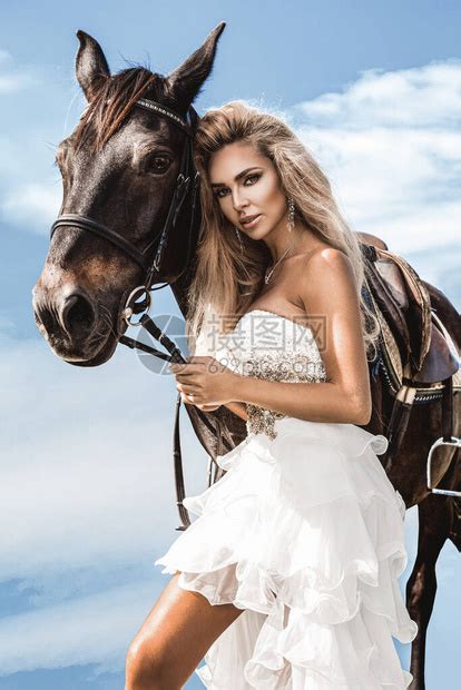 一匹黑马和女人的肖像一匹马的美丽魅力女人美丽的金发新娘穿着婚高清图片下载-正版图片506596006-摄图网