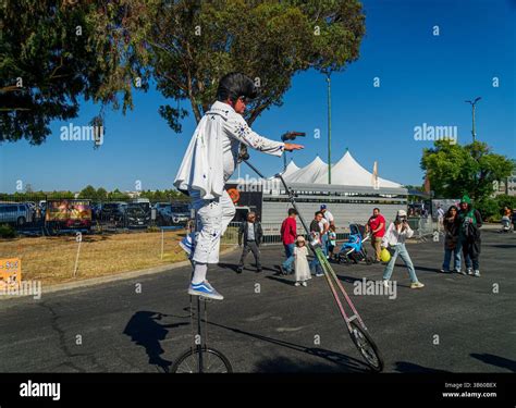 A street performer dressed as Elvis Presley rides a tall unicycle while ...