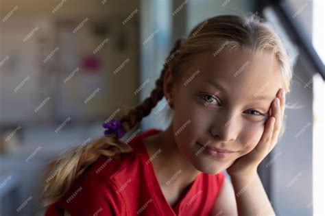 Premium Photo | Schoolgirl with blonde hair in plaits looking to camera ...