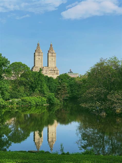 Download Buildings Reflected On Central Park Lake Wallpaper | Wallpapers.com
