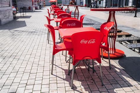 plastic red chairs and tables with Coca-Cola advertising logo in street ...