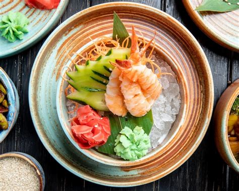 Top view of shrimps with sliced cucumbers and ginger on bamboo leaf on ...