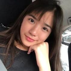 a woman sitting in the back seat of a car with her hand on her chin