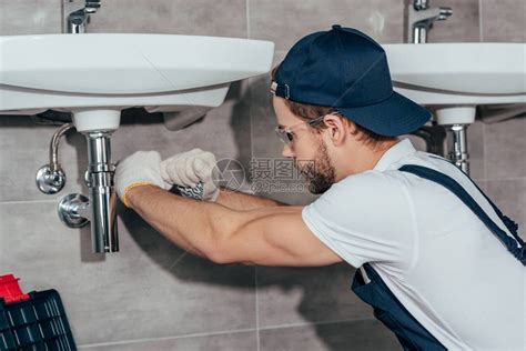 年轻专业水管工在浴室固定水槽的特写视图高清图片下载-正版图片502713958-摄图网