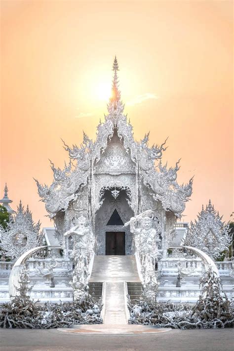 Golden light of sunset fills the sky at the White Temple in Chiang Rai ...