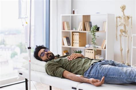 Tired sick male in casual wear drips medicine intravenously | Premium Photo