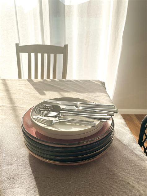 Forks and knifes on top of plates stack | Premium Photo