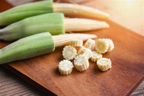 Baby corn on wooden cutting board, Fresh young baby corn for cooking ...