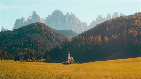 Download wallpaper 1366x768 building, mountains, lawn, forest, fog ...