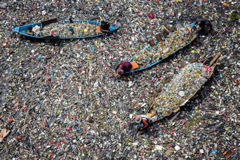 People on boats collect recyclable plastics from the heavily polluted ...