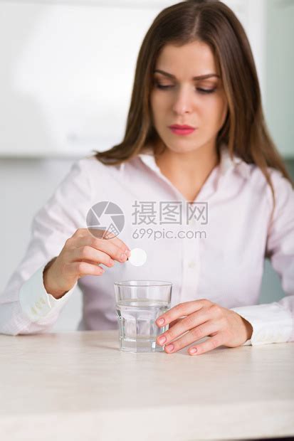 女人将止痛药放入一杯水中高清图片下载-正版图片502924852-摄图网