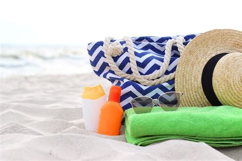 Beach accessories and sunscreens on the sand of the seaside | Premium Photo