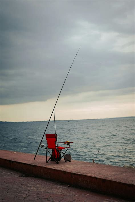 Man Sitting on Chairs on Sea Shore · Free Stock Photo