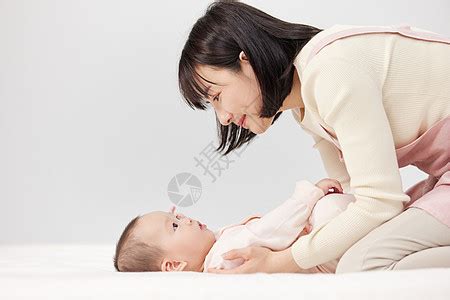 为忙碌的母亲照顾宝宝的月嫂高清图片下载-正版图片502384409-摄图网