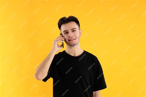 Premium Photo | Young man talk on phone on yellow background