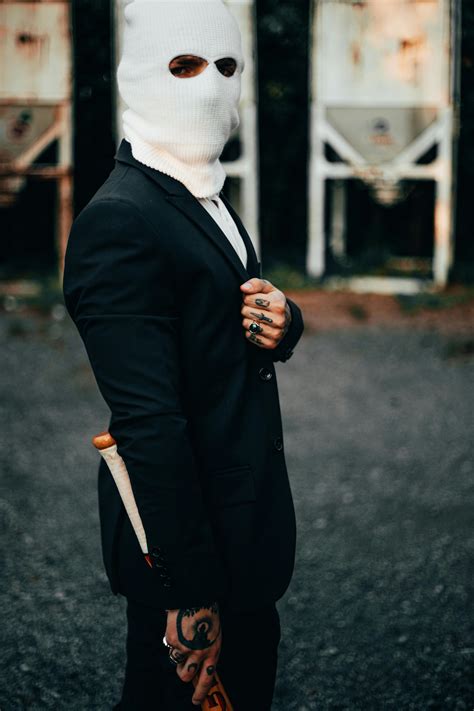 A Tattooed Man in a Ski Mask Making a Heart Sign · Free Stock Photo