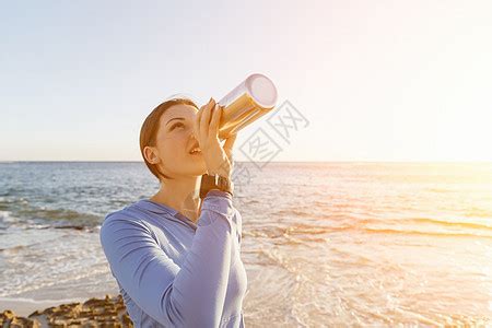 女人海滩上喝水轻女子海滩上锻炼后喝水高清图片下载-正版图片300524443-摄图网