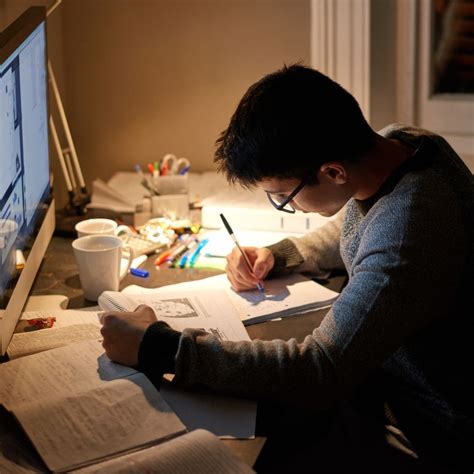 机に向かって勉強を始める人の写真