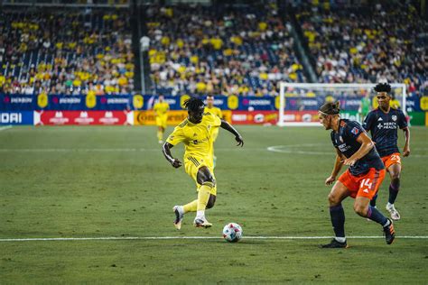 Download Soccer Match Action Yellowvs Orange Wallpaper | Wallpapers.com