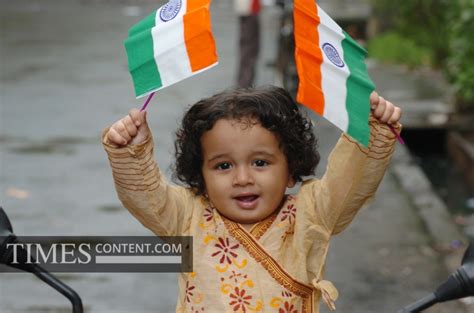 64th Independence Day News Photo A tiny tot waves a Nat...