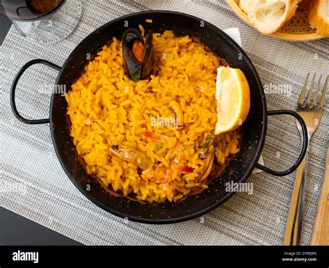 Traditional dish of Spanish cuisine is paella with seafood Stock Photo ...