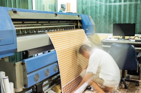 Technician roll up sticker business card banner during printing ...
