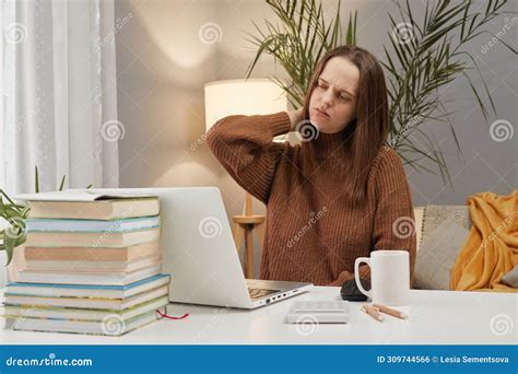 Tired Young Woman Wearing Brown Sweater Using Laptop while Working at ...
