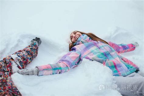 女人躺在雪地里做雪天使照片-正版商用图片0o6grh-摄图新视界