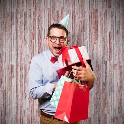 Mann, der eine rote Fliege und Partei-Hut trägt. Holding-Geschenk ...