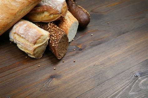 Different kinds of bread on wooden table | Premium Photo