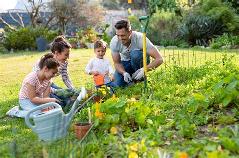Premium Photo | Happy caucasian family gardening and watering plants ...