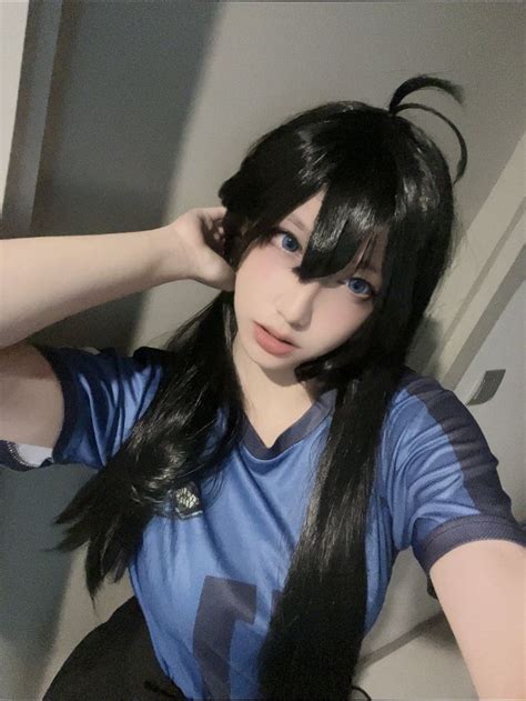 a woman with long black hair wearing a blue shirt and holding her hand ...