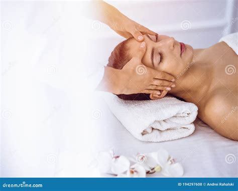 Beautiful Brunette Woman Enjoying Facial Massage with Closed Eyes in ...