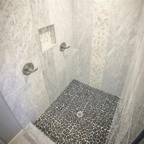 Elegant Carrara Marble Shower with Stylish Black River Rock Floor