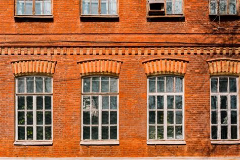 Ancienne façade en briques rouges avec d'immenses fenêtres vintage ...