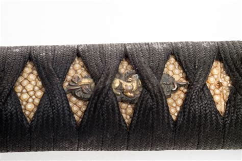 A short Japanese sword (wakizashi) with a black lacquered scabbard ...