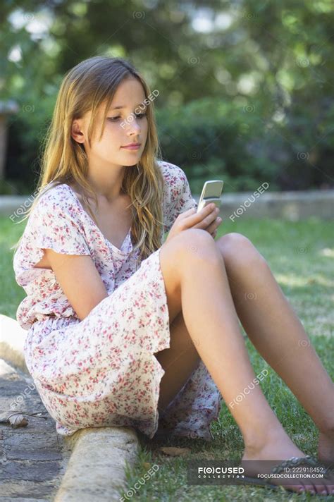 Cute teenage girl using a mobile phone in garden — Text Messaging ...