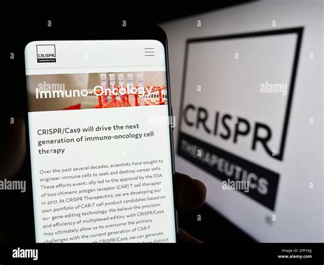 Person holding smartphone with web page of biotechnology company CRISPR ...