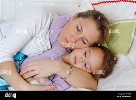 Mother and daughter cuddling on a bed in a kids room