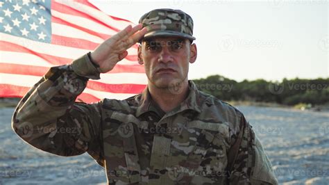 Military standing at attention next to the flag of their nation ...