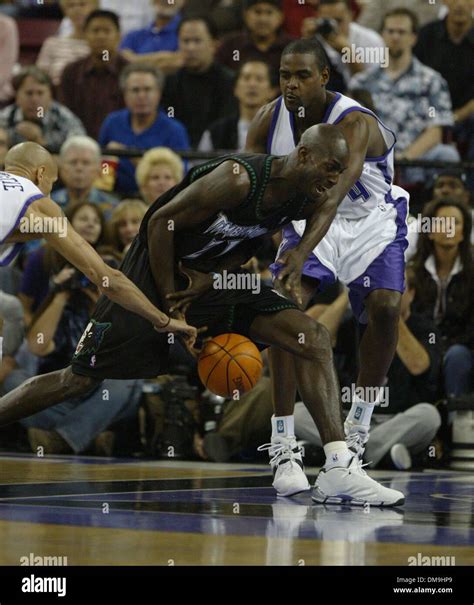 Kevin Garnett drives against Chris Webber as Doug Christie slips in to ...